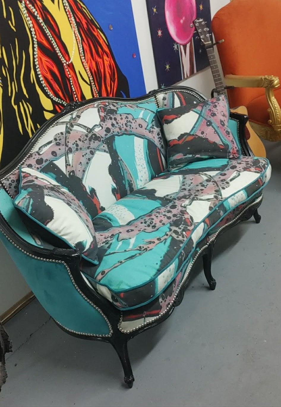 Carved settee with black lacquer frame and teal spin-painted upholstery